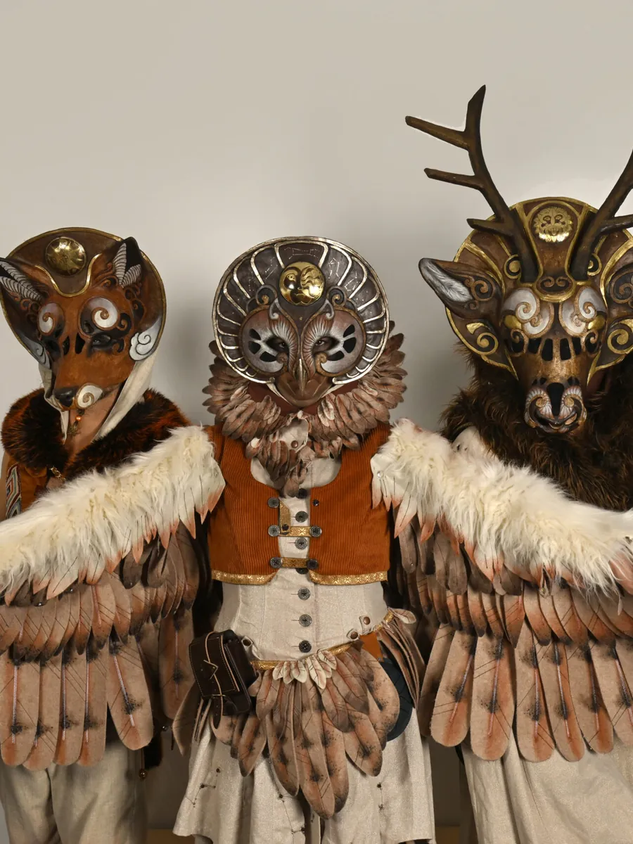 Les trois Runaînes, masques d'animaux et grandes ailes de plumes déployées
