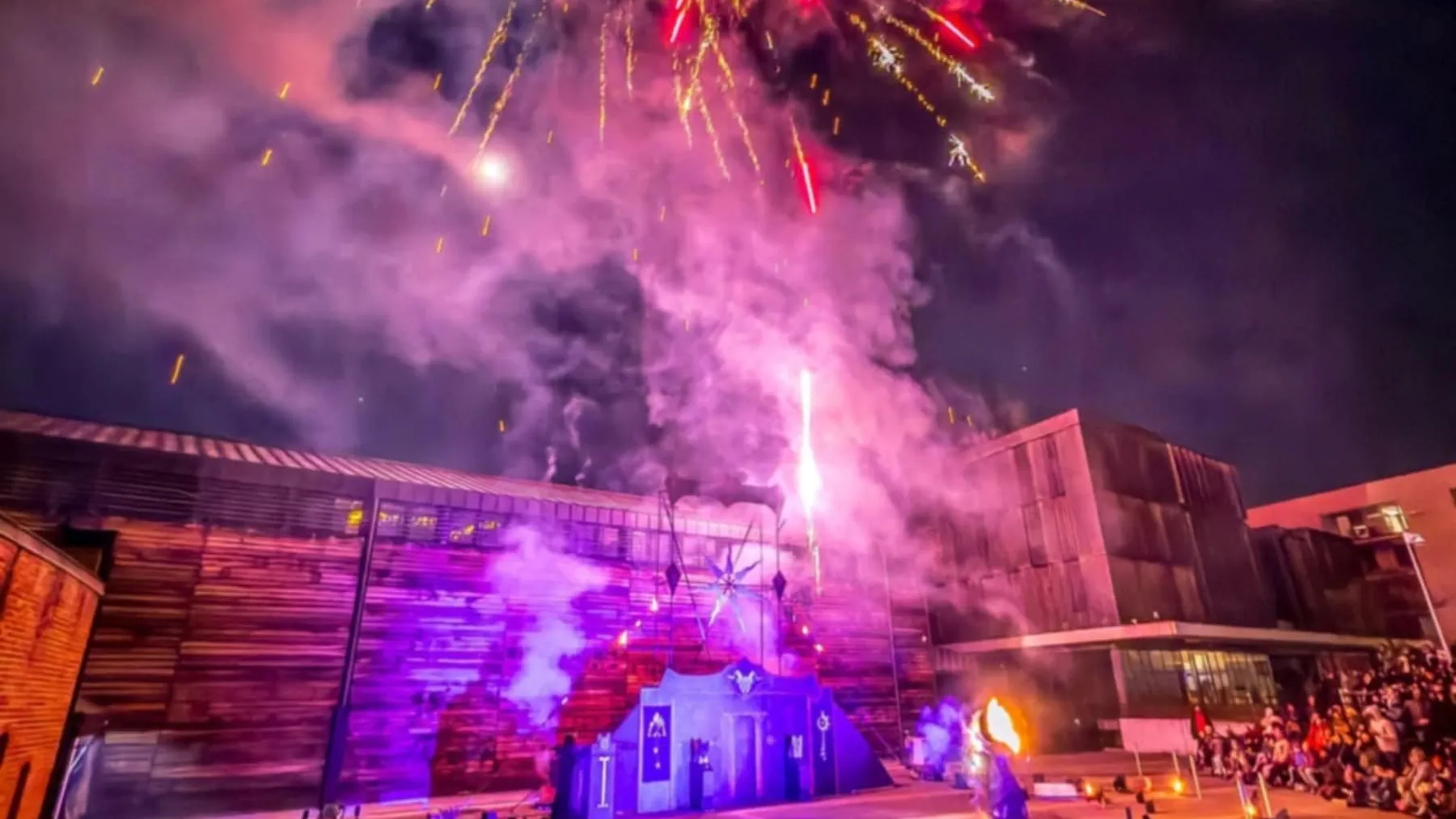 Gerbes pyrotechniques rouges et violettes au-dessus du décor de Portal Solaris